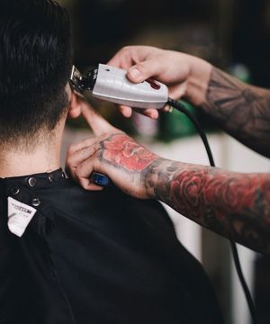 A barber running clippers over a client's neckline